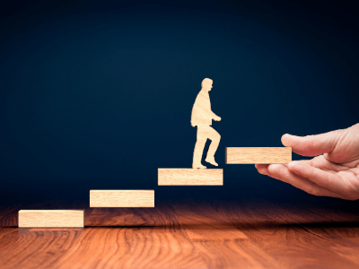 wooden block figure of a man climbing ladder rungs