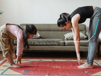 woman and daughter stretching with a printed sensor on the both's pants to monitor muscle activity