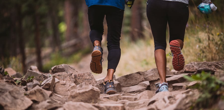 2 ladies running on a trail