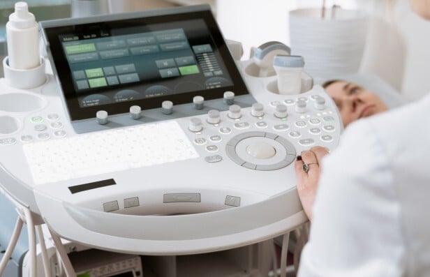 Doctor using an ultrasound machine with backlit controls